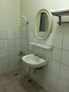 嘉义市永兴大旅社的一间带水槽和镜子的浴室