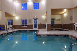埃姆斯GrandStay Hotel & Suites Ames的大楼内一个蓝色的大型游泳池