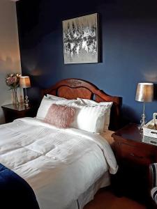 百利科内尔湖滨大道住宿加早餐旅馆的卧室配有白色床和蓝色墙壁