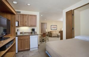 陶斯WorldMark Taos的酒店客房设有一张床和一个带水槽的厨房