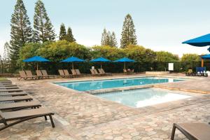 瓦克拉帕尼欧罗园林度假酒店的一个带椅子和蓝伞的游泳池