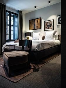 布鲁日Boutiquehotel 't Fraeyhuis的一间卧室配有两张床、一张桌子和一把椅子