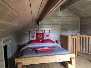 圣迪耶Le chalet des Cambuses的一间卧室配有一张带红色枕头的床