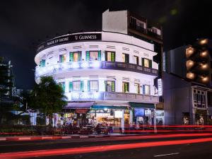 新加坡BEAT. Sports Hostel的前面有一条街道的高大的白色建筑