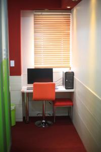 首尔阿里之家旅馆的办公室,配有书桌、电脑和红色椅子