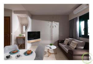 赫索尼索斯Irini Apartment Piskopiano, Hersonissos #2的客厅配有沙发和墙上的时钟