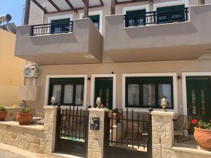 赫索尼索斯Irini Apartment Piskopiano, Hersonissos #2的一座带黑色门和栅栏的房子