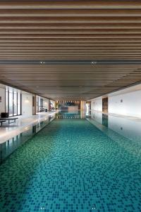 东莞东莞东城国际酒店（东城酒吧街）的一座大楼内一座带瓷砖地板的游泳池