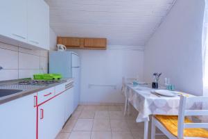 莫拉特岛Apartmani Mirko A1的厨房配有桌子和炉灶。 顶部烤箱
