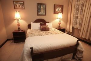 旺格努伊The Grand Hotel Wanganui的一间卧室配有一张大床和两盏灯