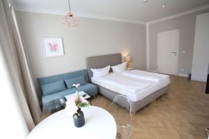 莱比锡Zollikof Aparts - Sauna & Studioapartments的一间带床和沙发的小卧室