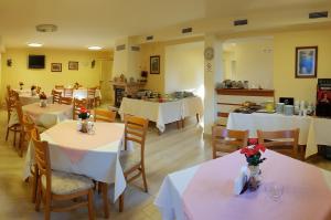 圣君士坦丁和海伦那Family Hotel Vega的餐厅配有桌椅和白色的桌布