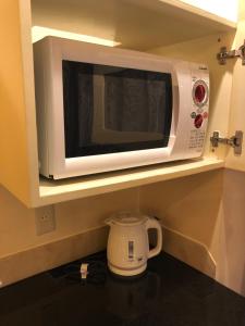 长崎长崎小型俱乐部情趣酒店（仅限成人）的厨房架上的白色微波炉