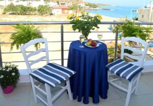莫拉托斯Meltemi Beach Apartments的阳台上的桌子和两把椅子以及一碗水果
