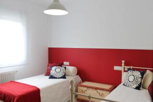 坎巴多斯Apartamento nuevo con terraza的一间卧室设有两张床和红色的墙壁