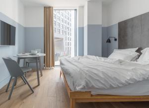 伦敦莱蒙洛克公寓式酒店的一间卧室配有一张床和一张桌子及椅子