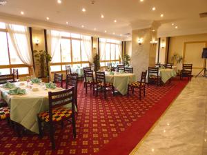 塞得港PortSaid Hotel的餐厅铺有红地毯,配有桌椅