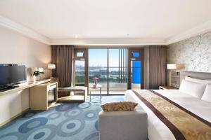 高雄高雄福容大饭店的酒店客房设有一张大床和一台电视。