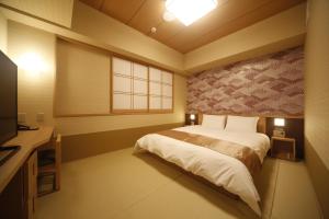 奈良御宿诺诺奈良天然温泉酒店的一间卧室配有一张床、一张书桌和一台电视