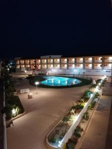 德尔锡伦西奥海岸Apartamentos Parque Carolina的一座大型建筑,晚上设有游泳池