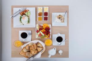 梅加洛克里梅赛文套房住宿加早餐旅馆 - 仅限成人入住的一张桌子,上面有早餐食品和咖啡