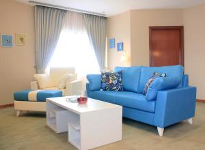 新加坡Alocassia Serviced Apartments的客厅配有蓝色的沙发和茶几
