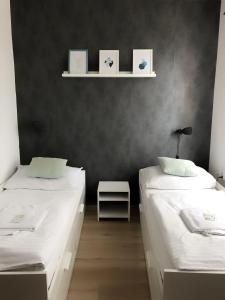 莫德日采格雷戈尔酒店的配有黑色墙壁的客房内的两张床