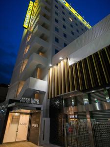 东京Super Hotel Tokyo JR Shinkoiwa的一座高大的建筑,上面有标志