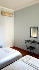 卡科瓦托斯Sea Side的客房设有两张床、镜子和桌子。