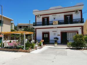 科孚镇Luna Bianca - Corfu Apartments的白色的房子,设有庭院和遮阳伞