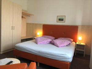 卡尔达罗拉特马尔旅馆的一间卧室配有一张带紫色枕头的床