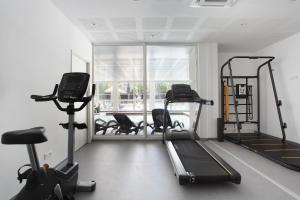 滨海卡瓦莱尔Résidence Prestige Odalys Les Canissons的健身房设有跑步机和椭圆机,并设有一个窗户