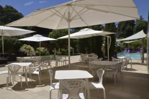 穆瓦萨克船主酒店的一组桌椅和白色遮阳伞