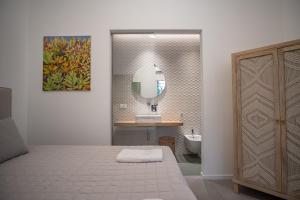 蒙德罗Mondello Felix - appartamenti in villa a 600m dal mare的浴室设有床、水槽和镜子