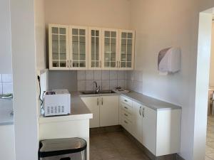 瓦玛里德Hlín Guesthouse的小厨房配有白色橱柜和水槽