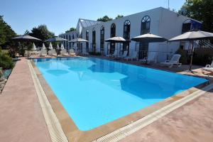 BessinesAgape Hotel Niort- Bessines的一个带椅子和遮阳伞的大型蓝色游泳池