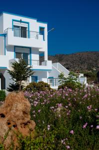 莫拉托斯Meltemi Beach Apartments的前面有鲜花的白色房子