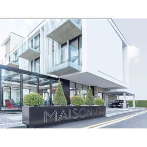 巴多利诺MaisonMe Boutique Hotel的前面有标志的大型白色建筑