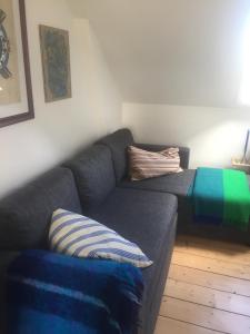 鲁德克丙Jette’s værelsesudlejning的客厅配有带条纹枕头的灰色沙发