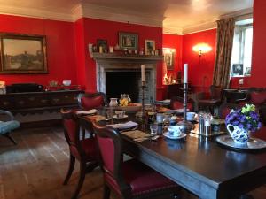 格兰瑟姆Marston Hall的一间设有桌子和红色墙壁的餐厅