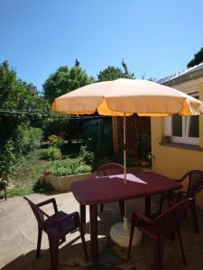 RevinGîte "La Maison"的一张带雨伞和两把椅子的野餐桌