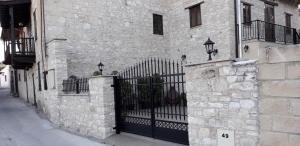 奥莫多斯Omodos Maria's Apartments的街道上一座石头建筑,有黑色的大门