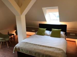 沃茨伯格Hotel Braun的一间卧室配有一张带绿色枕头的床和一扇窗户