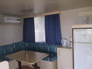 维尔Camp Sita的厨房配有一张沙发、桌子和一台冰箱