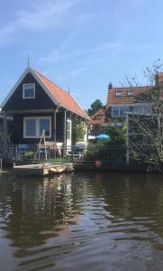 WestzaanHet Pulletje的水面上码头上的房屋