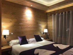 圣洛伦索-德莫鲁尼斯皮特尤斯旅馆的一间卧室设有两张床和木墙