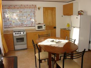 安加罗阿Turismo Vinapu的厨房配有桌子和白色冰箱。