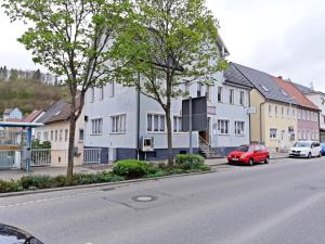 阿尔布斯塔特Hotel & Hostel Albstadt的停在一排房子前面的一辆红色汽车