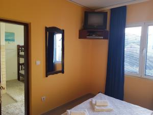 蒂瓦特桑德拉公寓的卧室配有镜子和墙上的电视