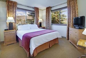 六月湖海德堡度假酒店的酒店客房,配有床和电视